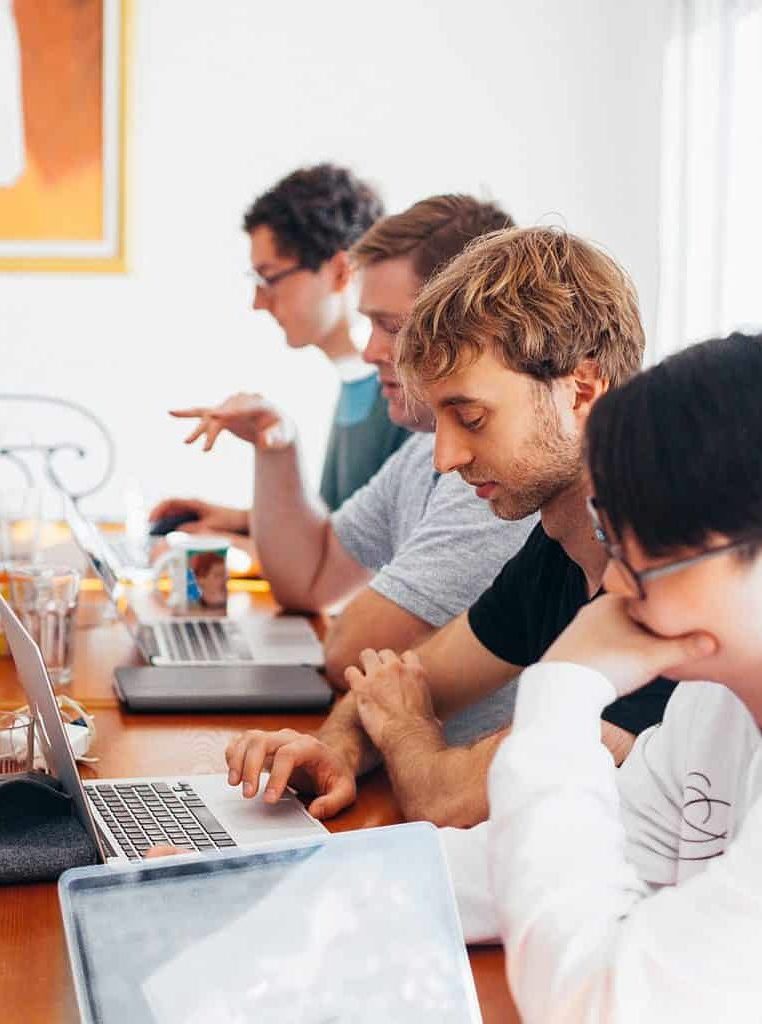Group of people working on laptops in a meeting room