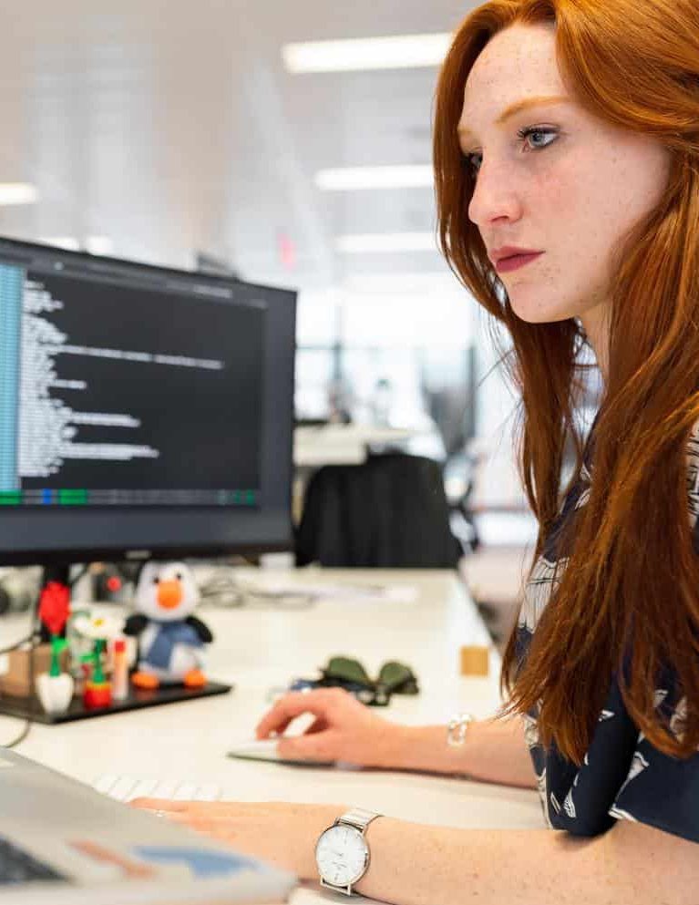 Woman working on code at a computer