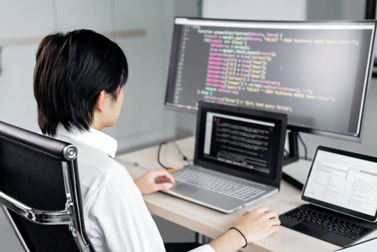 Man sitting with back to camera coding