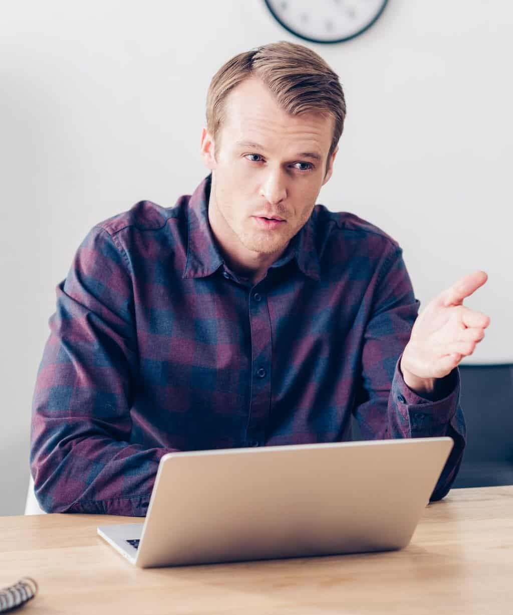 handsome male video blogger recording video blog and gesturing in office