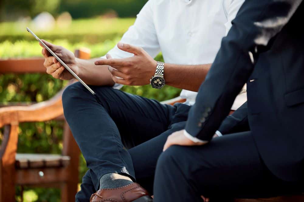 Two people discussing a notebook outdoors