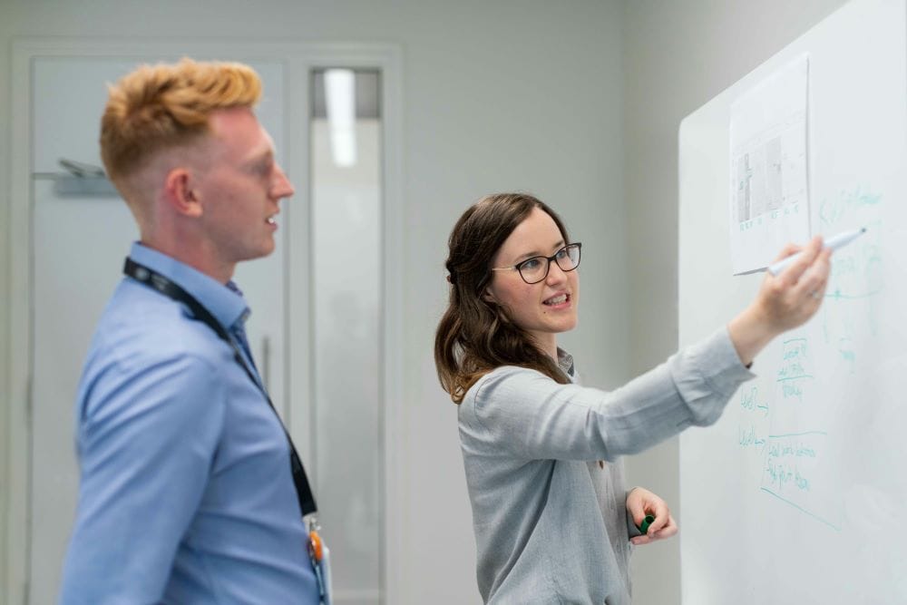 Professional Man and Woman at Whiteboard