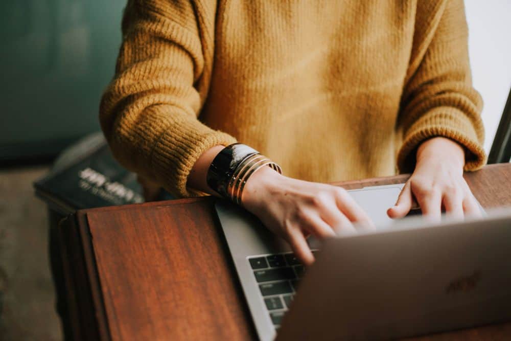 Person In Yellow Jumper at Laptop